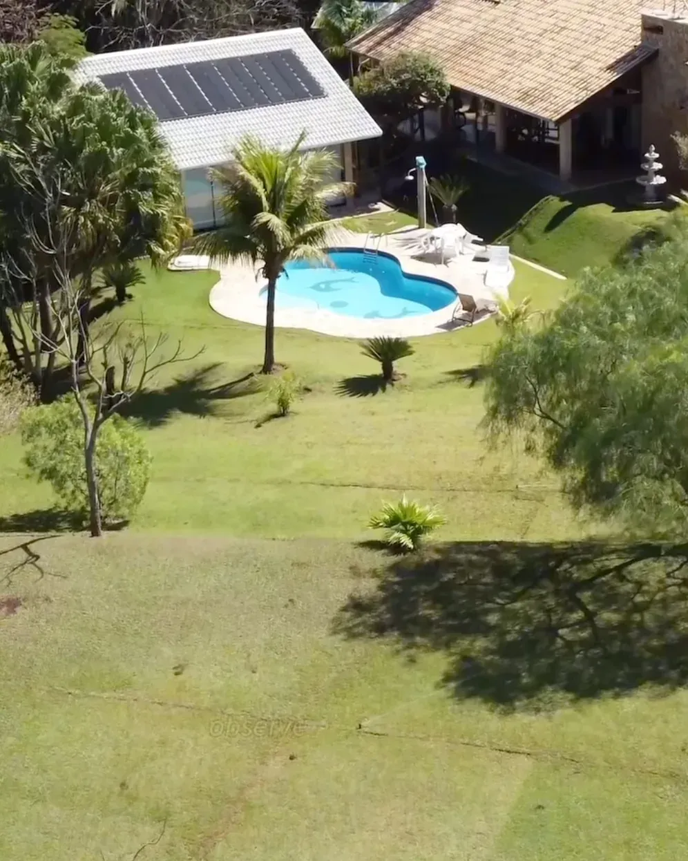 Vista aérea de casa com piscina, gramado e paisagismo residencial