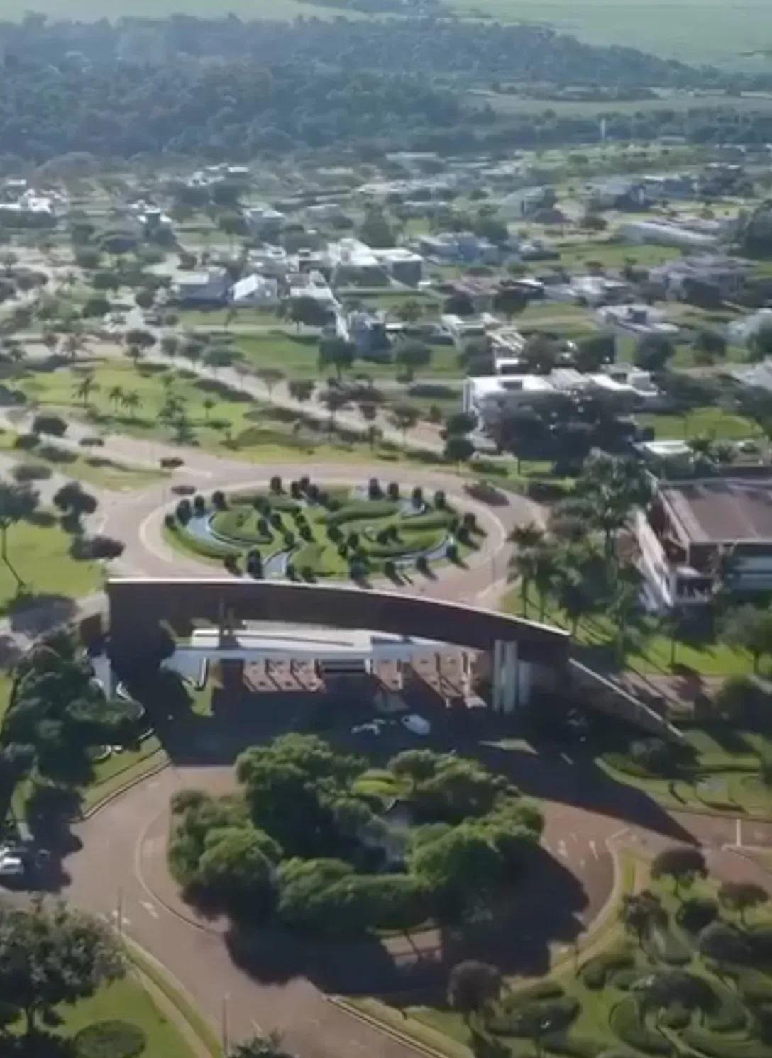 Vista aérea de condomínio com áreas verdes e jardins residenciais