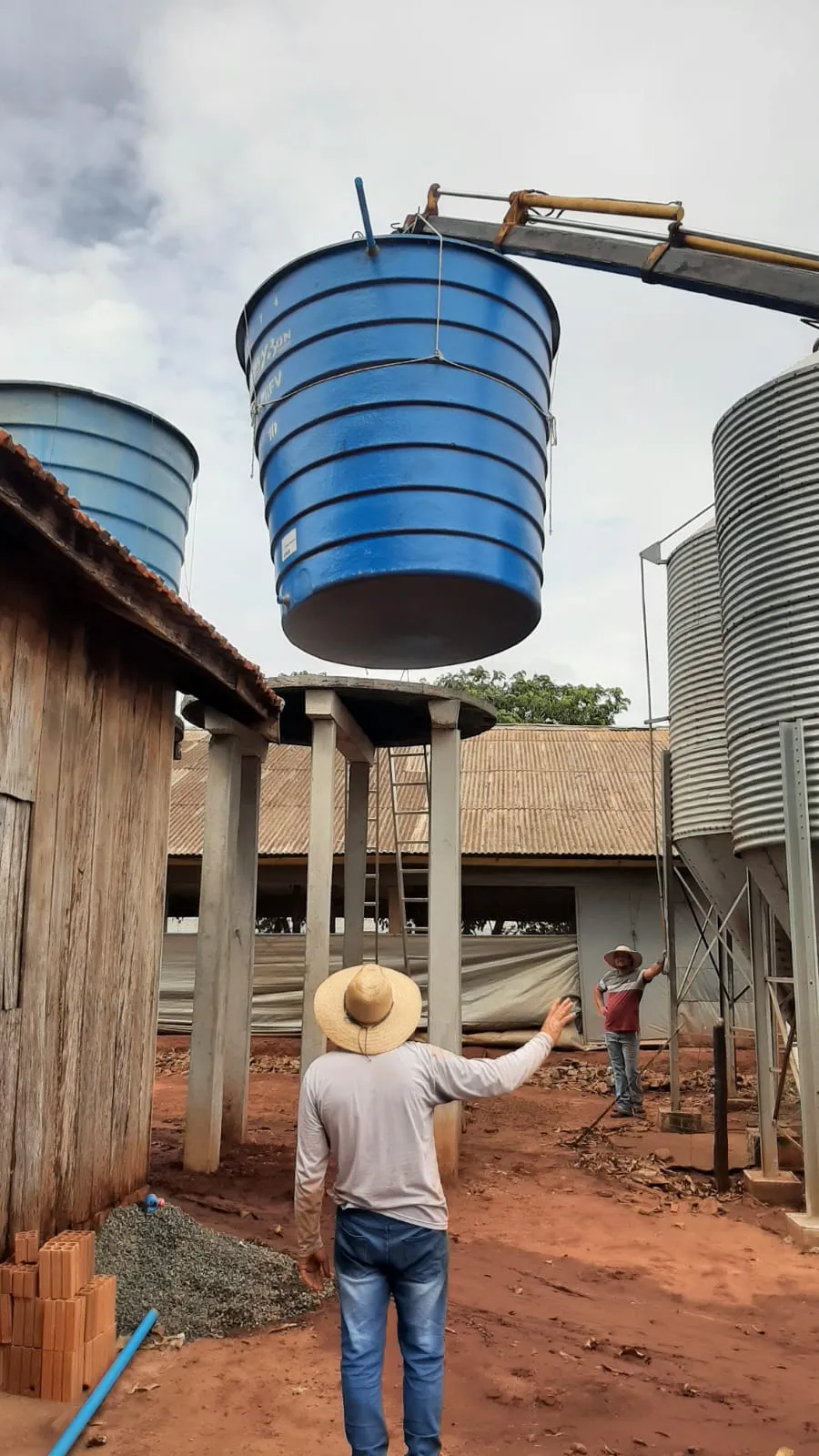 Reservatório elevado sendo instalado em estrutura de granja