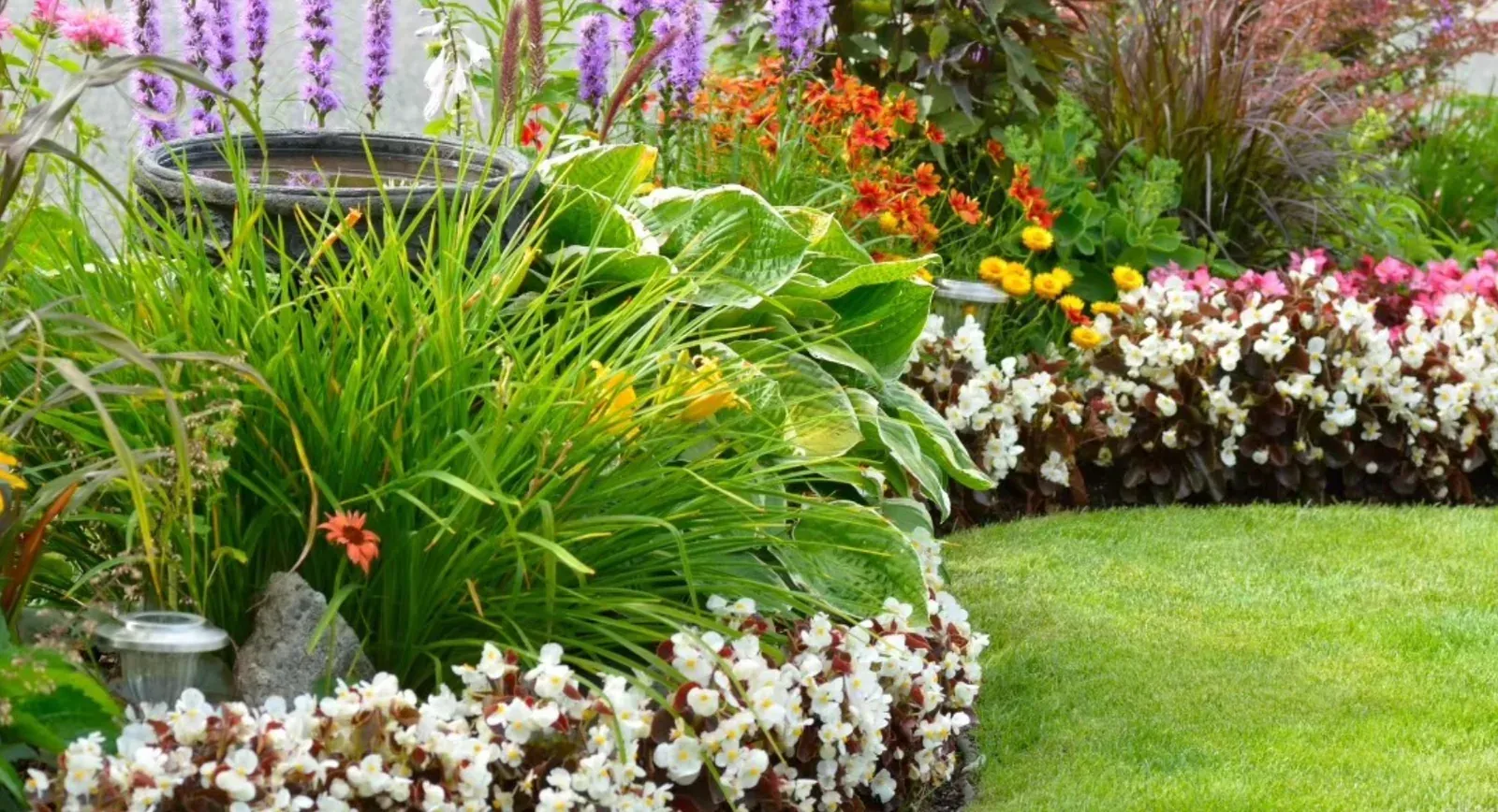 Jardim florido com gramado aparado e canteiros coloridos