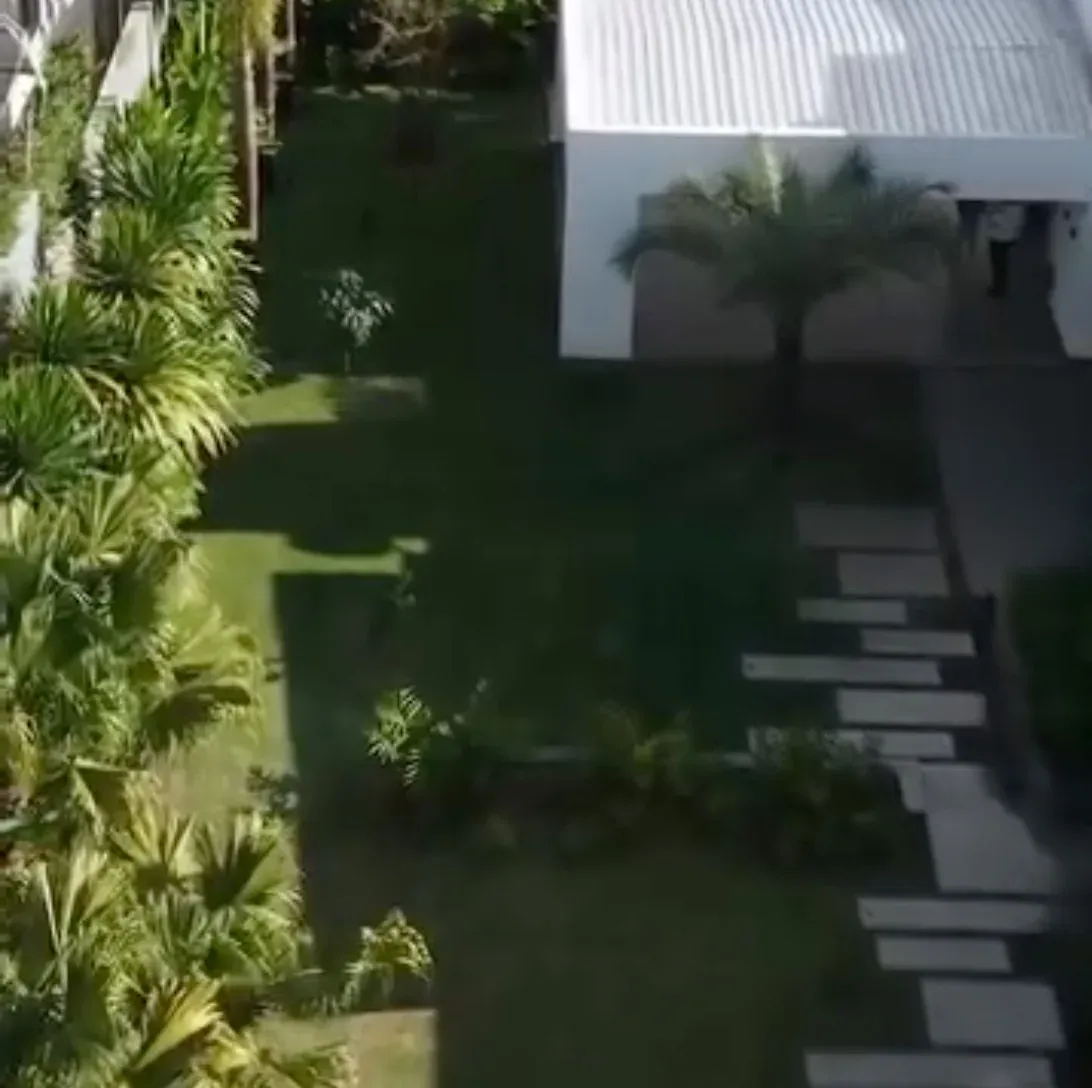 Jardim residencial visto de cima com gramado e caminho de pedras