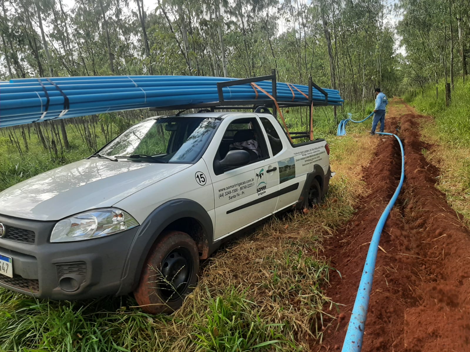 Caminhonete da Somar transportando tubos ao lado de uma valeta