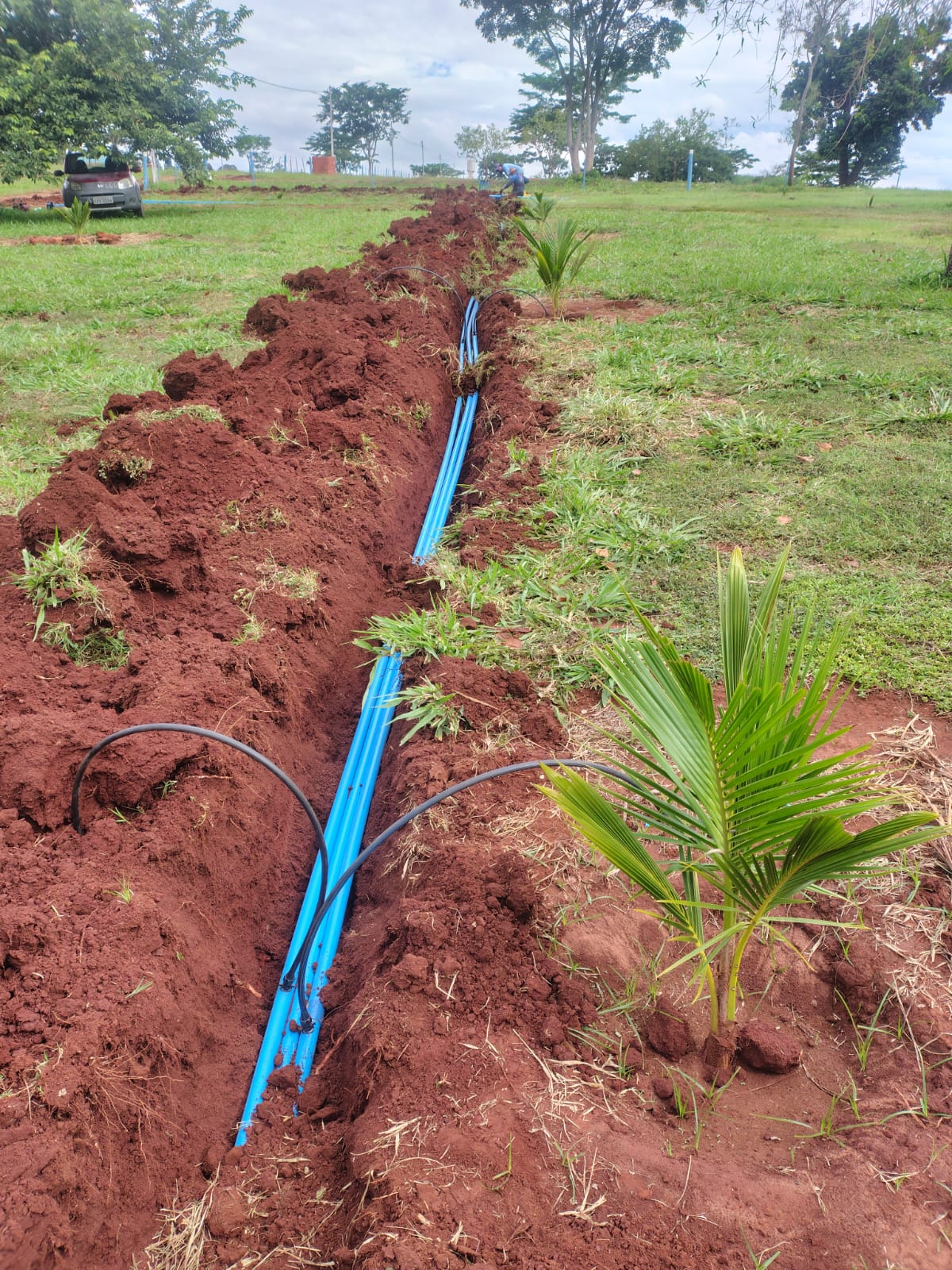 Tubulação azul instalada em valeta aberta no campo